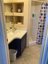 Bathroom with tile patterned floors, vanity, and walk in shower