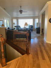 Living room with ceiling fan, french doors, hardwood / wood-style floors, lofted ceiling, and a textured ceiling