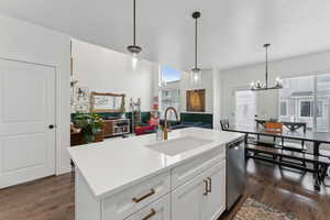 Kitchen with pendant lighting, dishwasher, a center island with sink, white cabinets, and sink