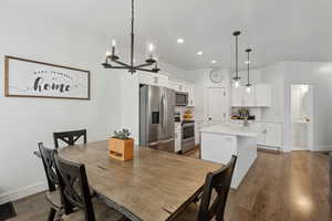 Dining space featuring hardwood / wood-style flooring, sink, and a notable chandelier