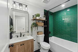 Full bathroom with vanity, toilet, a textured ceiling, and shower / tub combo