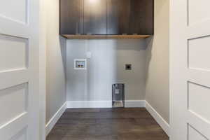 Laundry area with electric dryer hookup, hookup for a washing machine, cabinets, and dark hardwood / wood-style floors