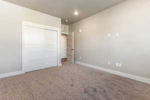 Unfurnished bedroom featuring carpet and a closet