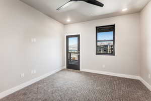 Carpeted spare room with ceiling fan