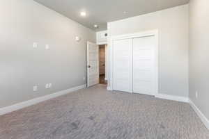 Unfurnished bedroom with carpet flooring and a closet