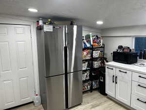 Kitchen with white cabinets and new refrigerator which is included