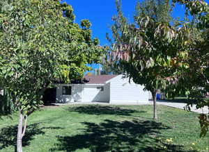 Summer view of front facade featuring abundant fruit trees