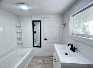 Bathroom featuring vanity, LVP flooring and shower / bathtub combination. Photo taken after renovation before owners moved in.