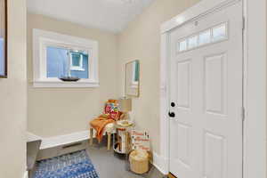 Entrance foyer with a textured ceiling and hardwood / wood-style flooring