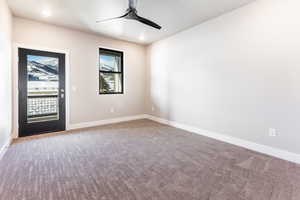 Unfurnished room featuring carpet floors and ceiling fan