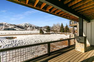 Snow covered back of property with a mountain view