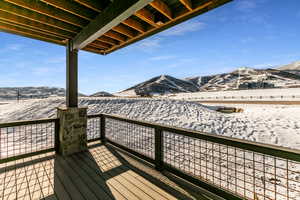 Snow covered deck featuring a mountain view