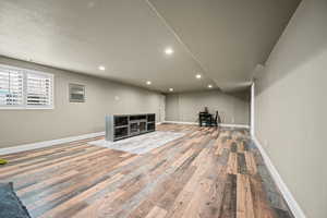 Basement with a textured ceiling and hardwood / wood-style flooring