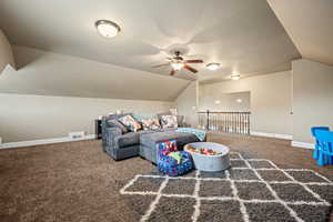 Interior space featuring carpet, ceiling fan, and lofted ceiling