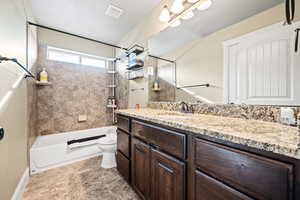 Full bathroom featuring vanity, toilet, and tiled shower / bath