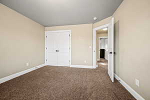 Unfurnished bedroom with carpet and a closet