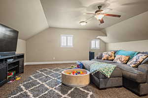 Interior space with dark carpet, ceiling fan, and lofted ceiling