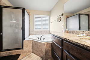 Bathroom featuring vanity and independent shower and bath