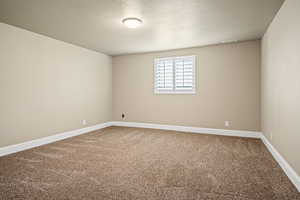 Spare room featuring carpet flooring and a textured ceiling