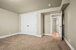 Unfurnished bedroom with carpet and a textured ceiling