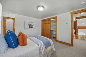 Bedroom with a closet and light colored carpet