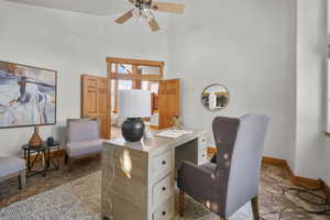 Office area featuring ceiling fan and a high ceiling