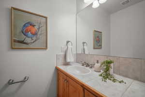 Bathroom with tasteful backsplash and vanity