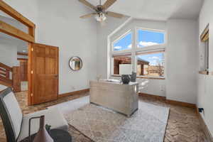 Office area featuring ceiling fan and high vaulted ceiling