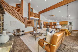 Living room featuring ceiling fan, high vaulted ceiling, and beamed ceiling