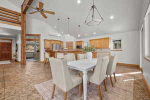 Dining area featuring ceiling fan and high vaulted ceiling