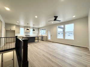 Kitchen with hanging light fixtures, stainless steel dishwasher, ceiling fan, a kitchen island, and a kitchen bar