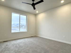 Carpeted empty room with a mountain view and ceiling fan