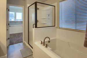 Grand master Bathroom featuring tile patterned flooring and shower with separate bathtub