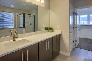 Primary Bathroom with vanity, tile patterned floors, and walk in shower