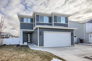 View of front of house featuring a garage and a front lawn