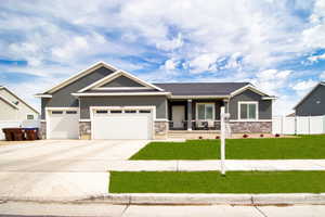 Craftsman-style home with a front lawn, stone siding, and stucco siding
