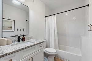 Full bathroom with hardwood / wood-style flooring, vanity, toilet, and shower / tub combo