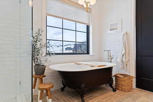 Primary Bathroom with a mountain view, a bathtub, tile walls, natural light