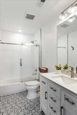 Full bathroom with shower / bath combination with glass door, vanity, and toilet