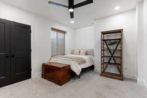 Basement Bedroom featuring light carpet and ceiling fan