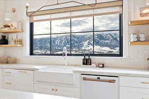 Kitchen featuring white cabinetry, Nordic Valley Ski Resort views, sink, and white dishwasher