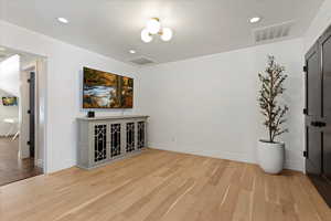 Upstairs loft room with hardwood / wood-style floors and an inviting chandelier