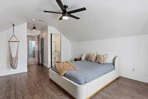 Bedroom with wood-type flooring, ensuite bath, ceiling fan, and lofted ceiling