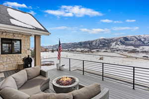 Deck with a mountain view and a fire pit