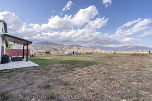 View of yard featuring a mountain view, a rural view, and a patio area