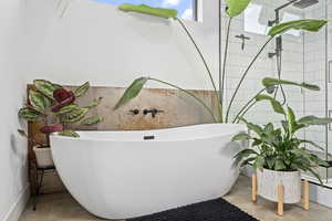 Bathroom with a bathing tub and concrete flooring