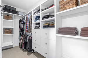 Walk in closet featuring light colored carpet