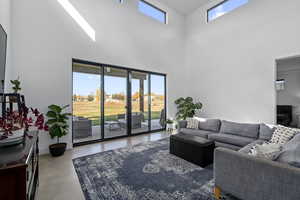 Living room with concrete flooring and a high ceiling