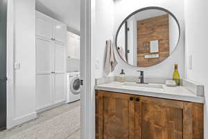 Bathroom with vanity and washer / clothes dryer