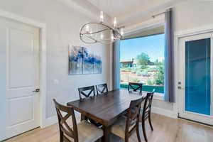 Dining area with an inviting chandelier and light hardwood / wood-style flooring